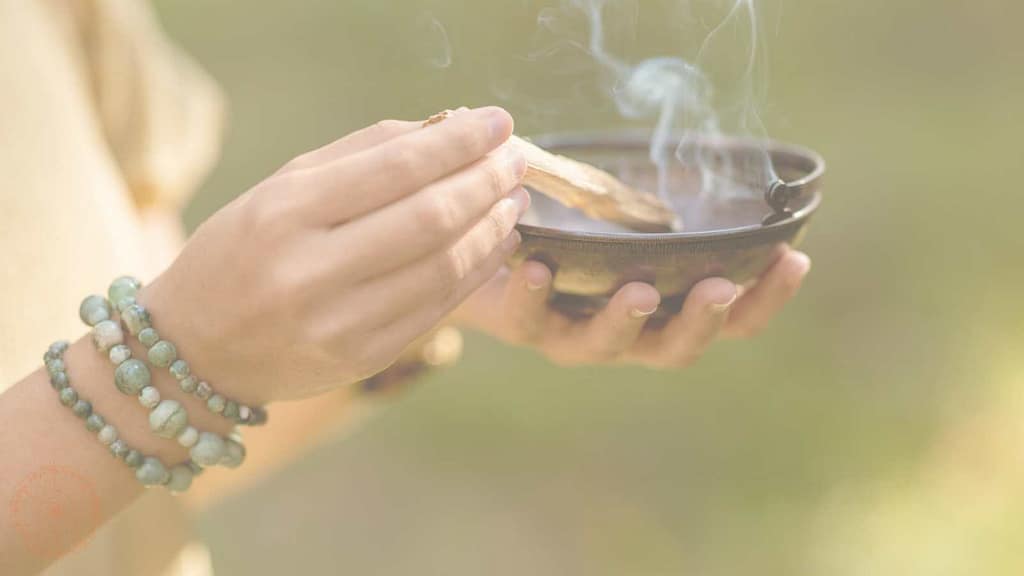 schamanisches räucherritual frau räuchert mit palo santo abnehmen auf allen ebenen schamanisch