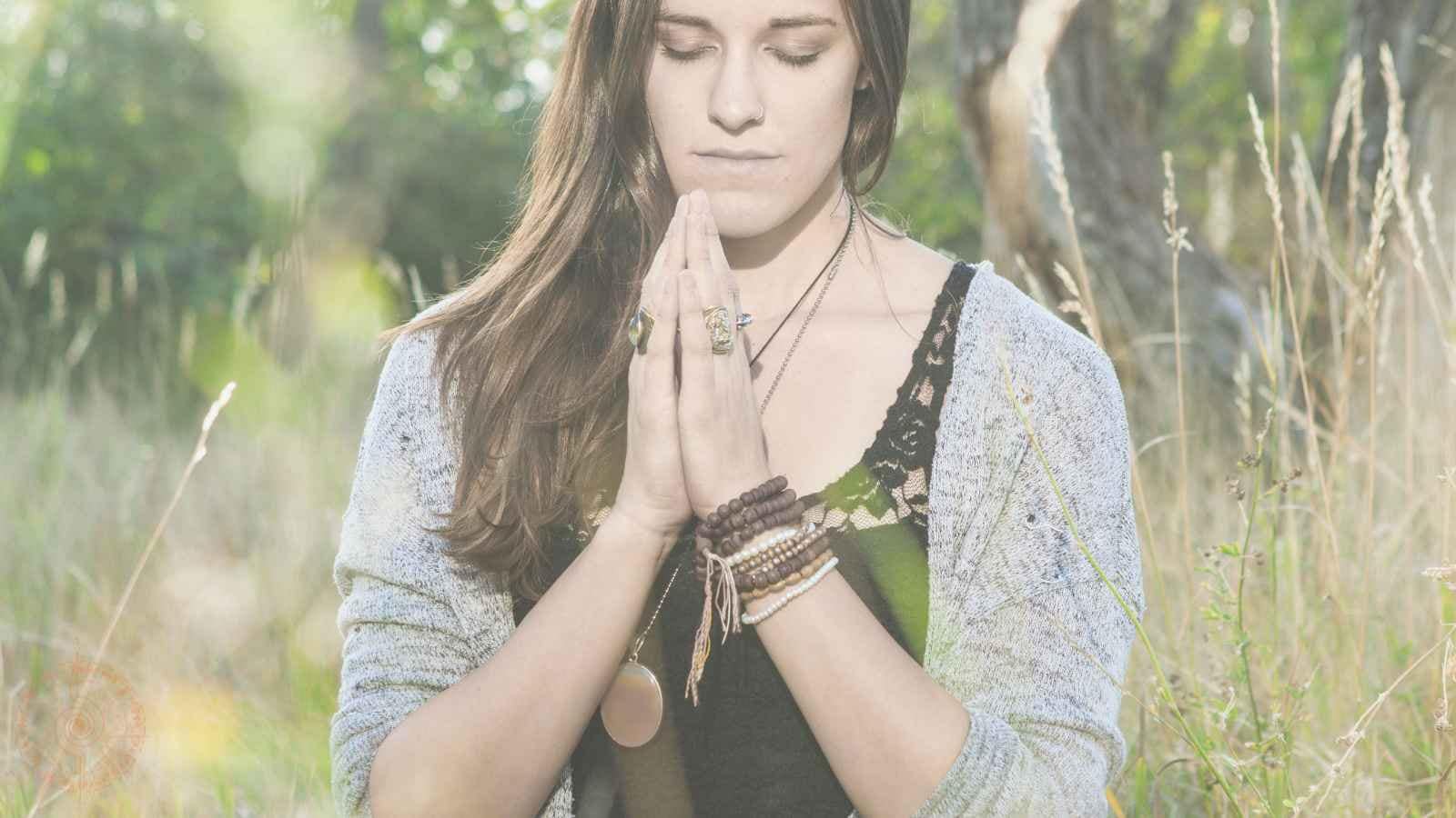 was ist spiritualität eine frau sitzt mit geschlossenen augen in der natur