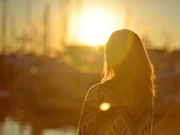eine frau schaut glücklich in die abendsonne schamanismus online kurs